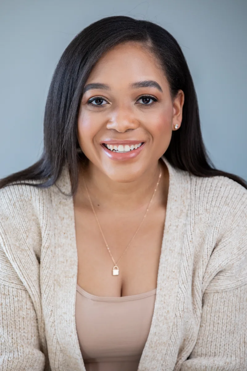 Portrait of attorney Renée Abara, smiling, in a cream cardigan