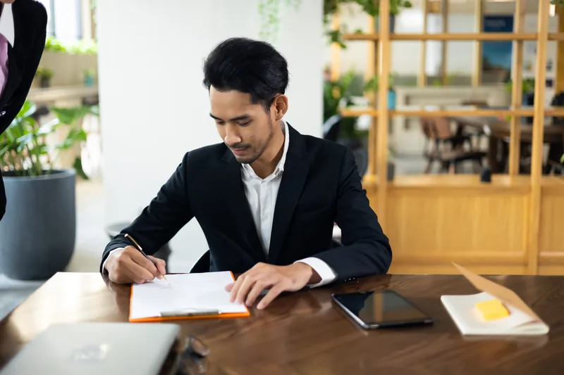 A business owner reads a contract before signing it
