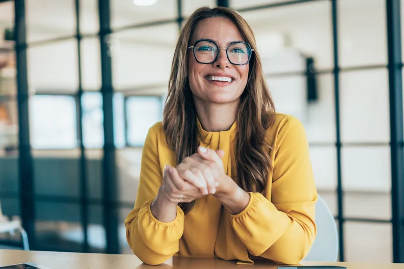 Portrait of attorney Hannah Brecht smiling, in a yellow sweater