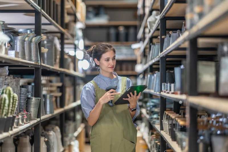 A woman checking stock with a tablet in her family's ceramics shop