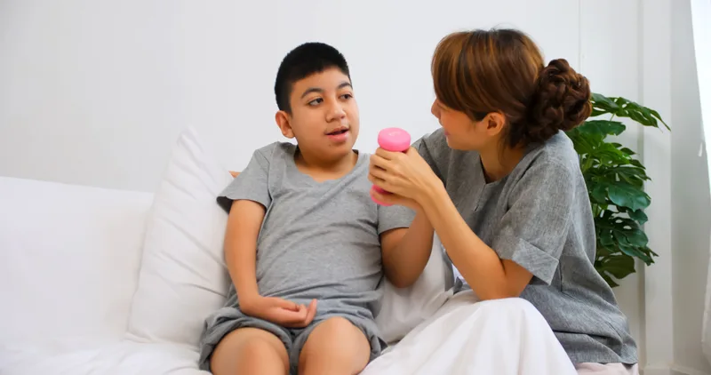 A mother doing a hand exercise with her son at home