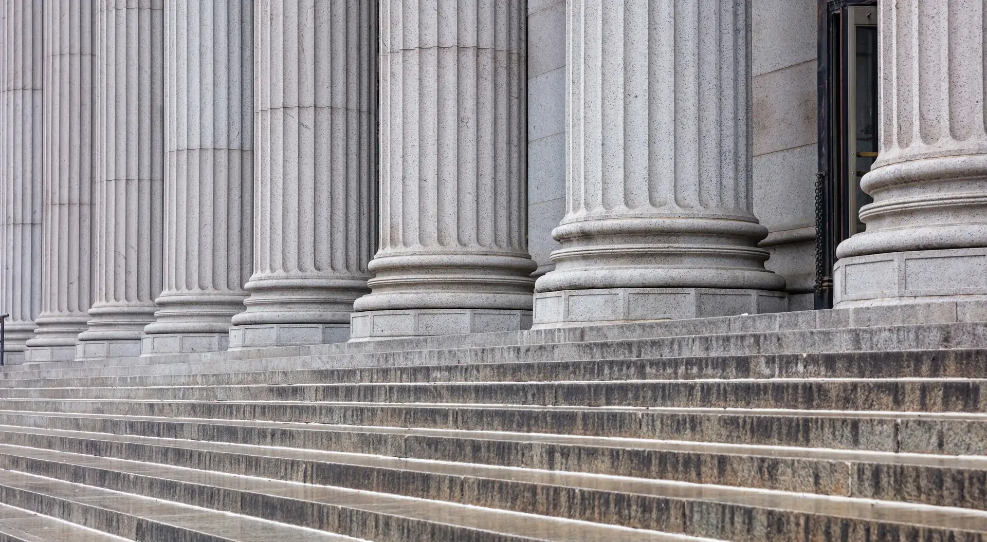 Granite steps and fluted columns of a New York courthouse — the arena where Sterling Justice Law tries its cases