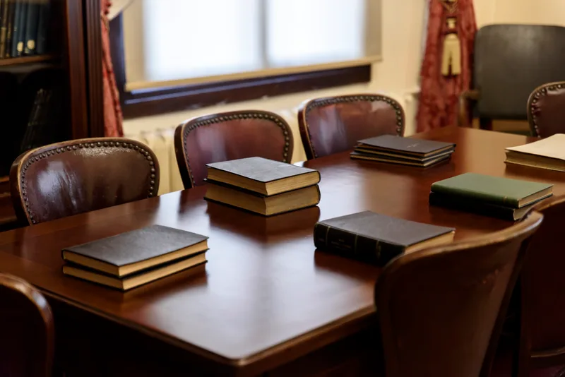 The firm's boardroom: bound volumes laid out on a long mahogany conference table ringed by studded leather chairs