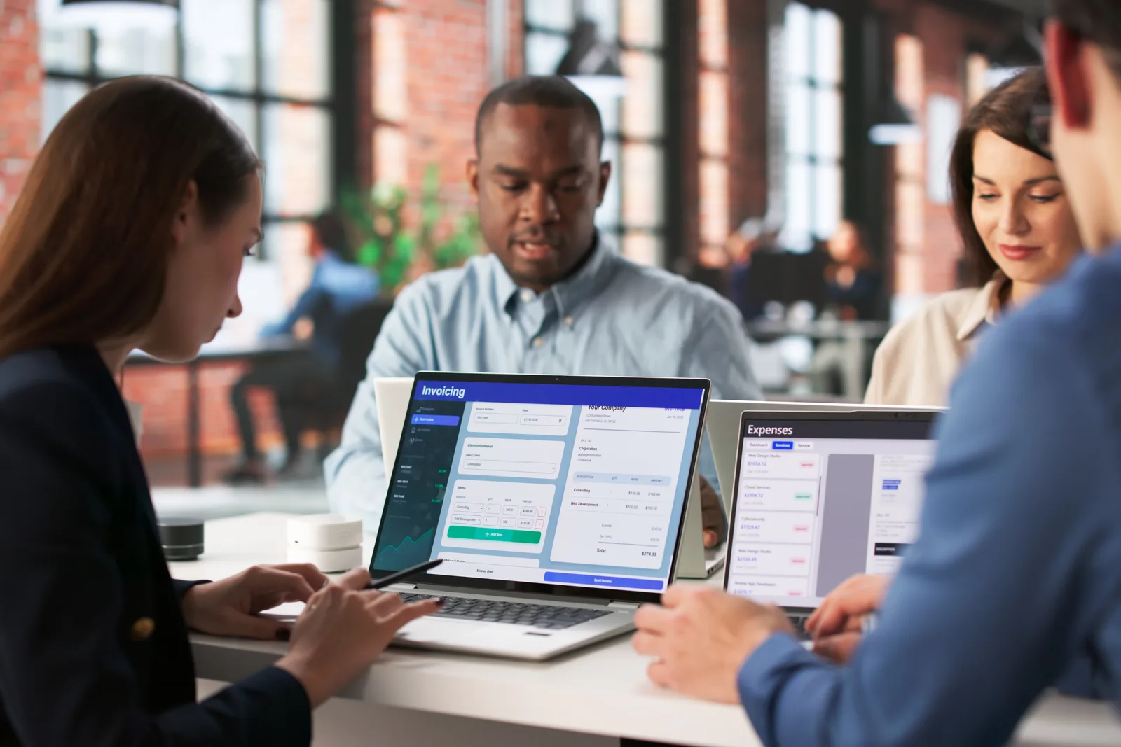 Small business owner and bookkeeper reviewing a reconciled income and expense dashboard together on a laptop