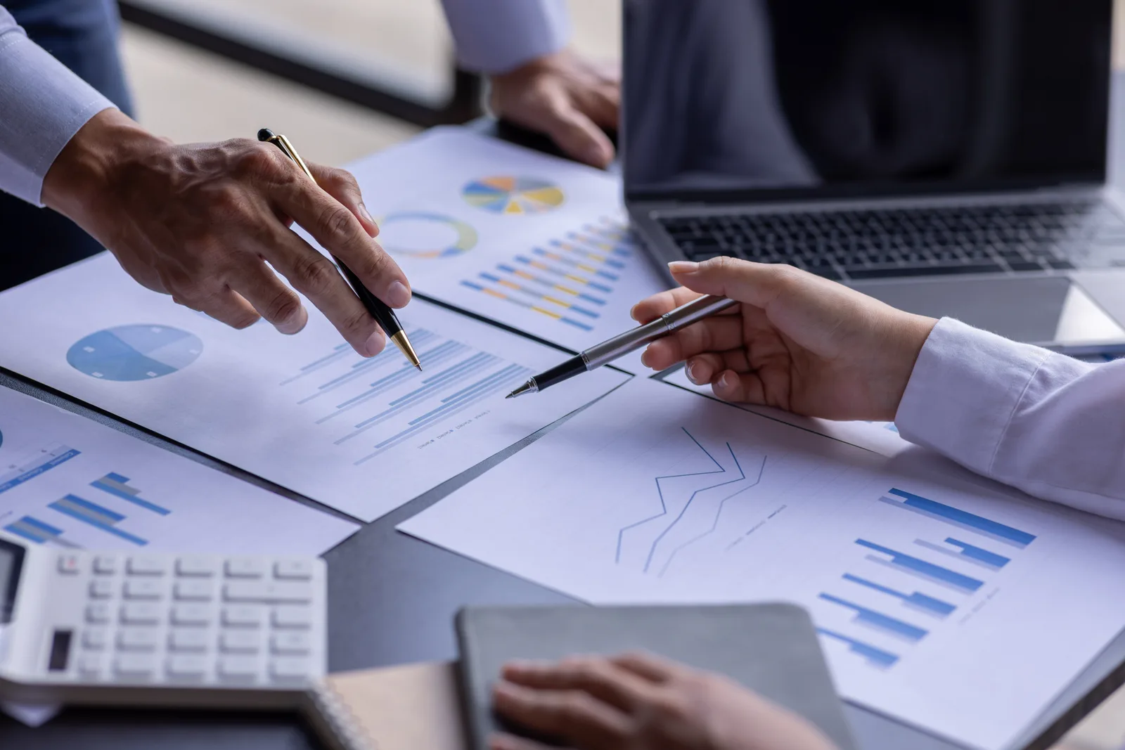 Finance and accounts payable team reviewing an invoice-approval dashboard together at a laptop in their office