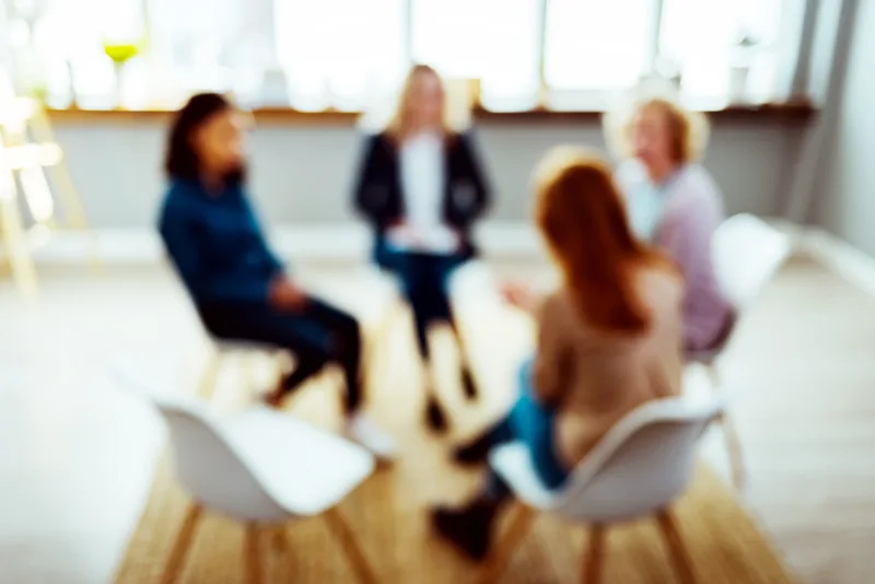 Supportive group therapy session in a bright room