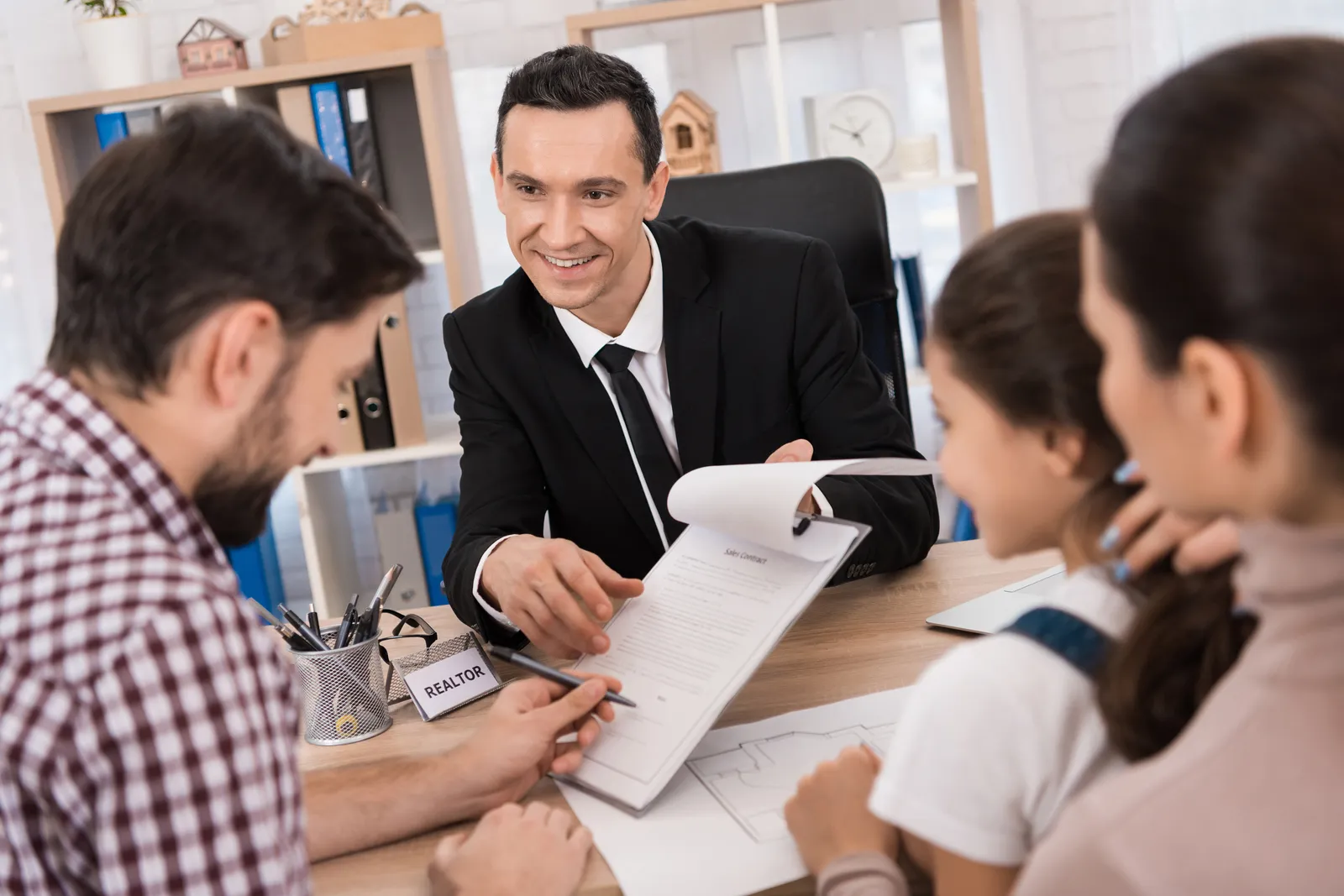 Adoption attorney reviewing finalization paperwork with a smiling family at her office desk