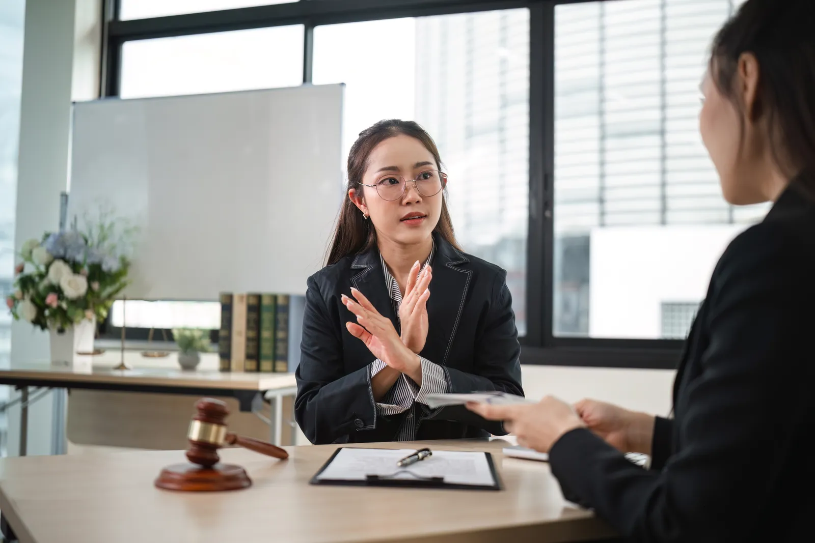 Antitrust attorney reviewing a merger filing with a client's general counsel at a conference table