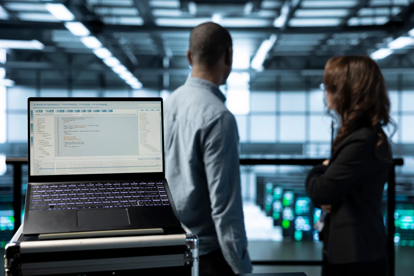 Platform engineers reviewing API gateway traffic and rate-limit dashboards together on a laptop in their office