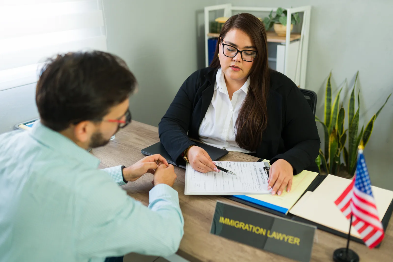 Asylum attorney reviewing a client's written declaration and supporting evidence together at her desk