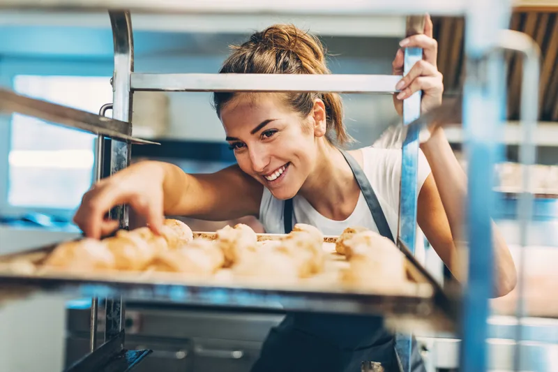 Baker checking freshly baked croissants in a bakery
