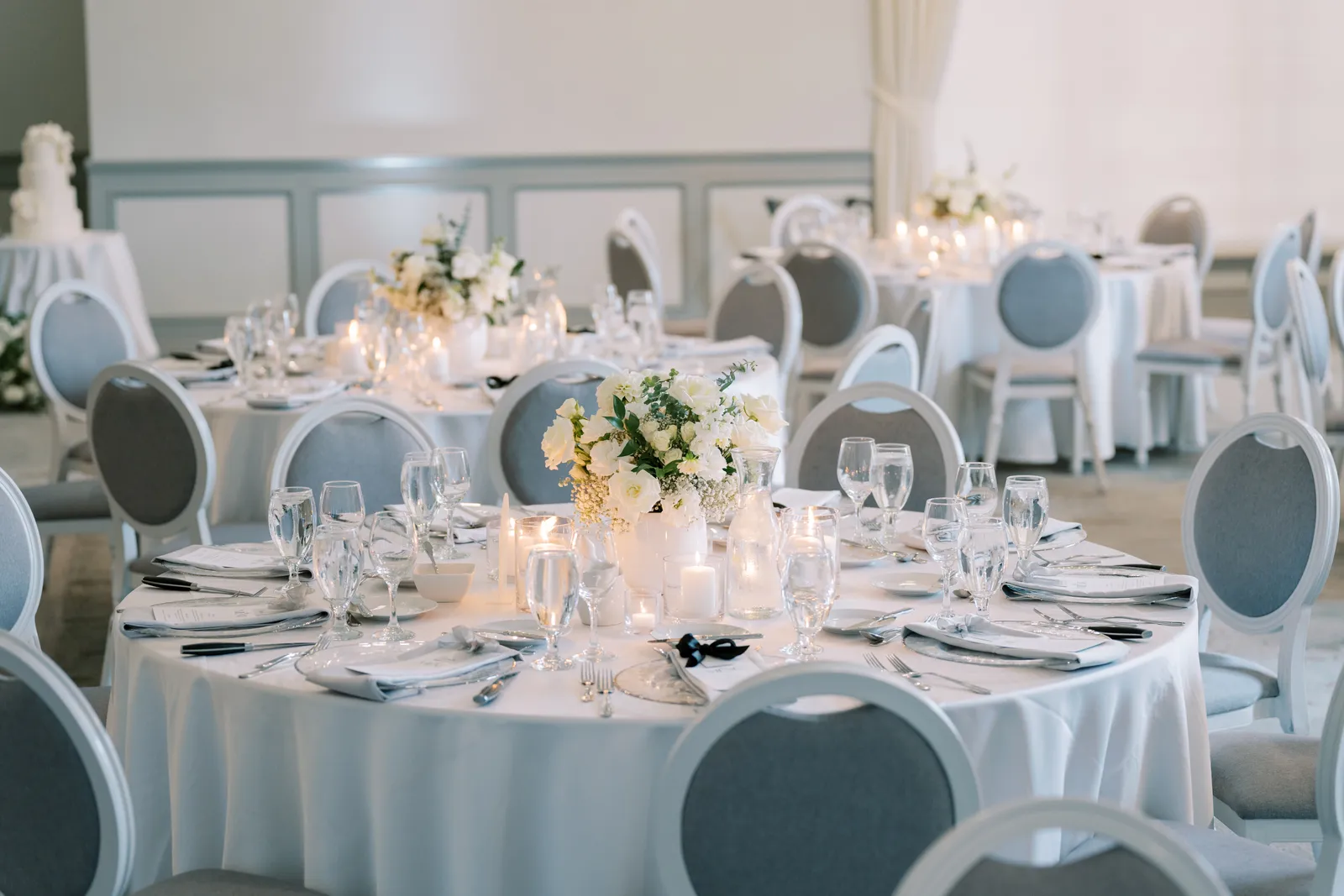 Banquet hall ballroom set with round tables, white linens, and floral centerpieces for an evening event