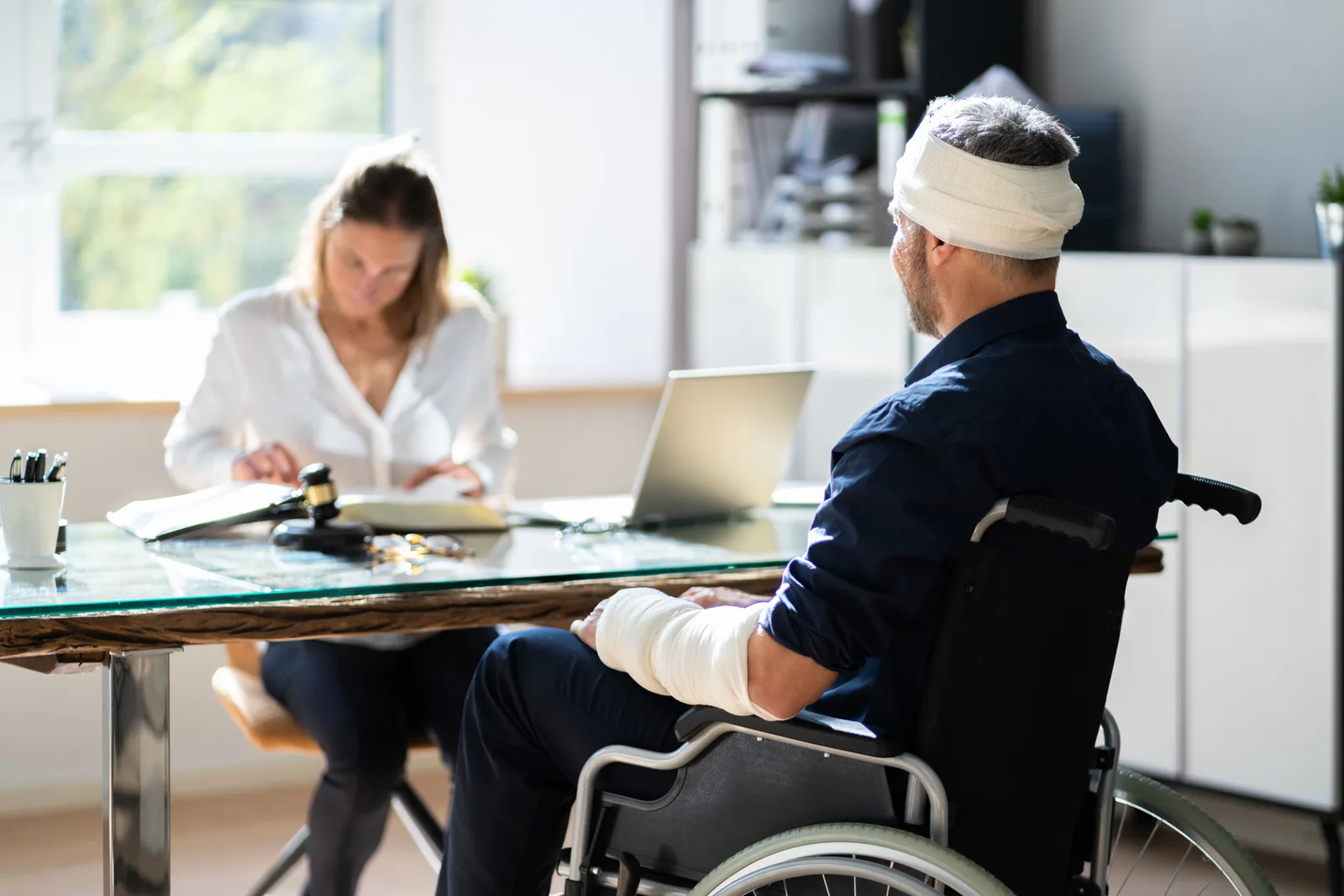 Brain injury attorney reviewing brain scan images and a life care plan with a client's family at a law office conference table