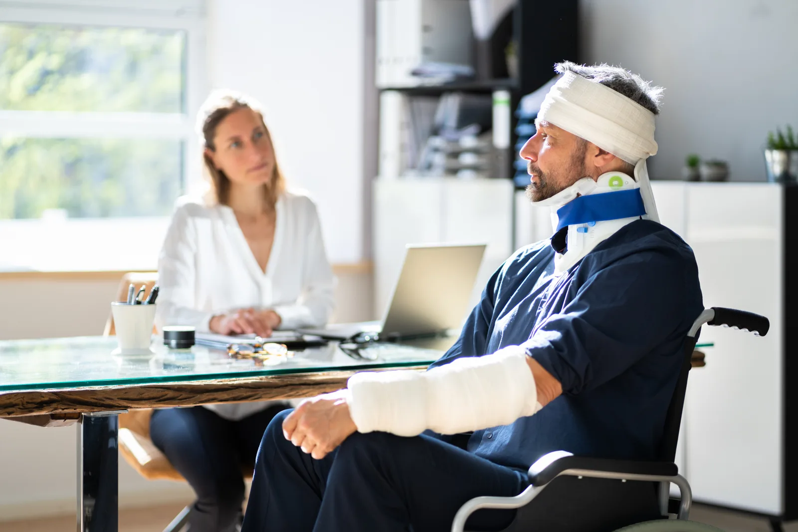 Burn injury attorney reviewing hospital burn-unit records and a life care plan with a client at a law office conference table