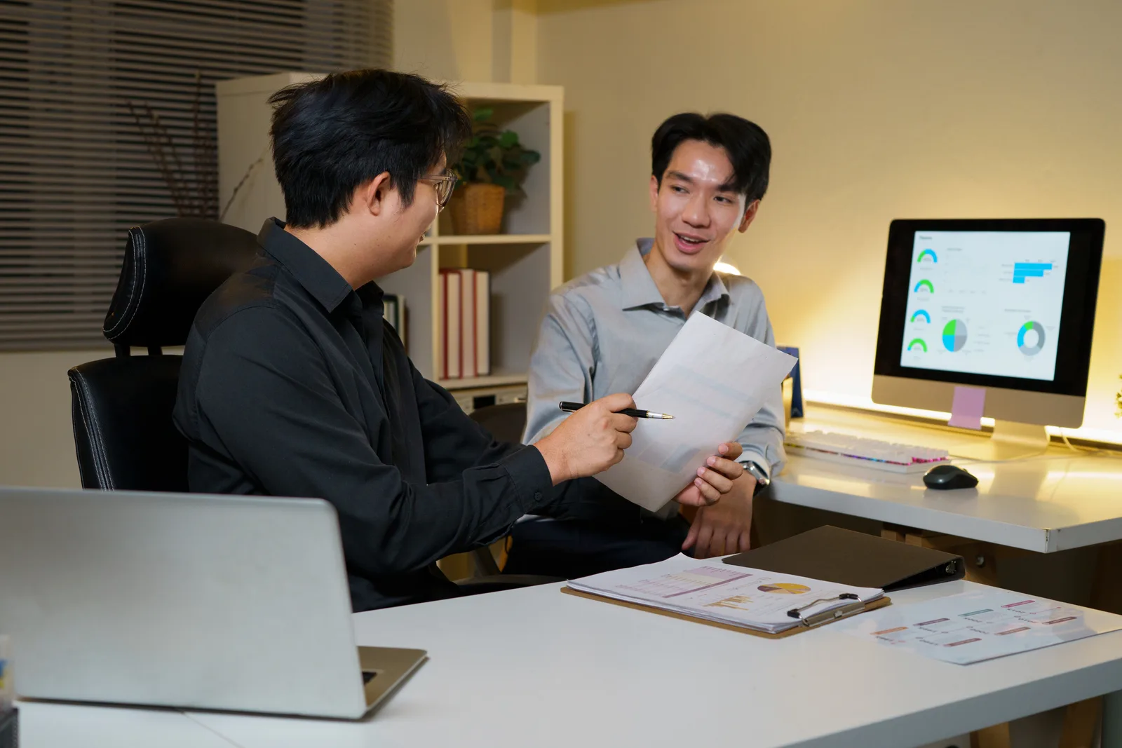Data team reviewing a dashboard of charts and KPI metrics together at a laptop in their office