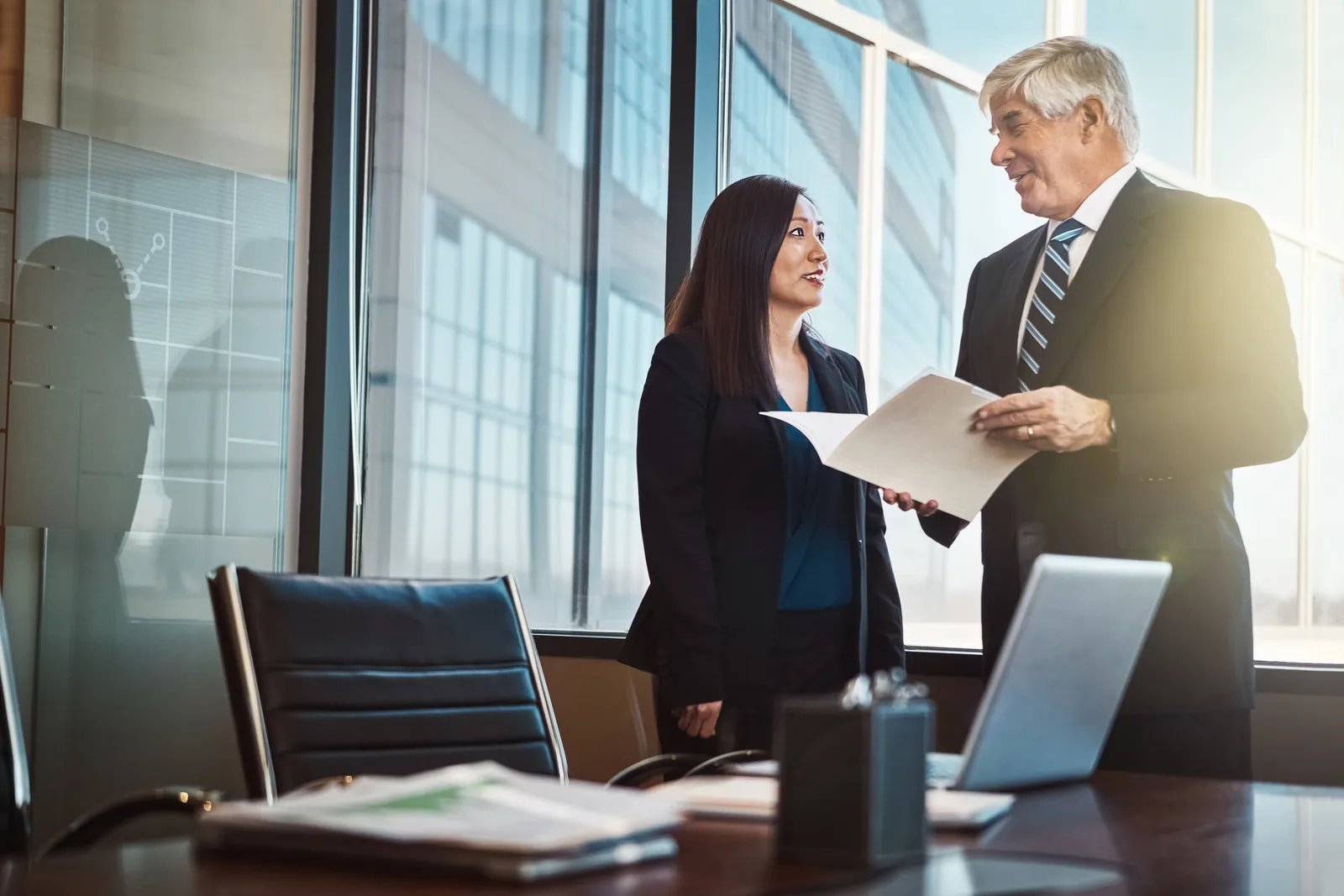 Business attorney reviewing a contract with a small business owner at a conference table