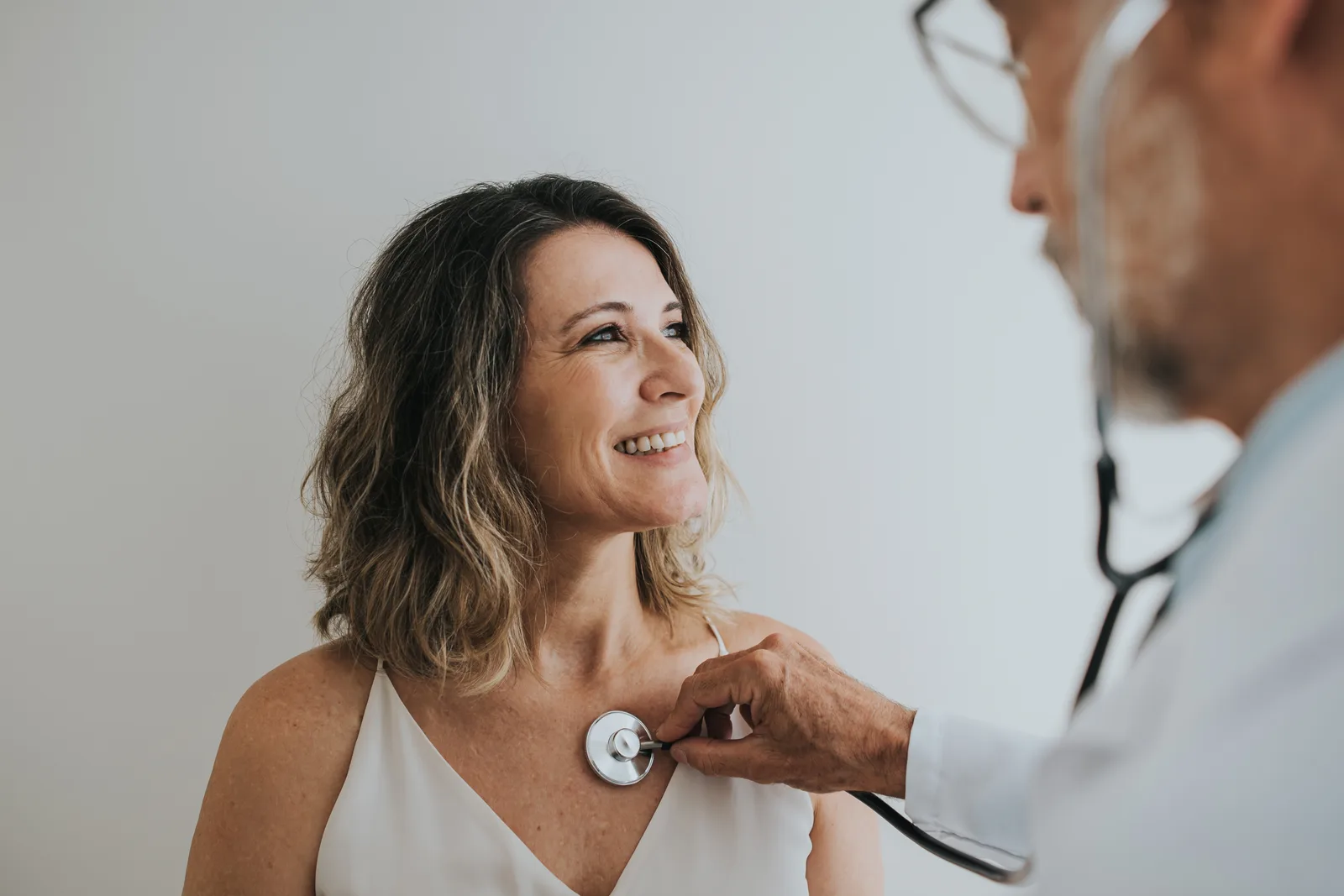 Cardiologist listening to a patient's heart with a stethoscope during an office visit