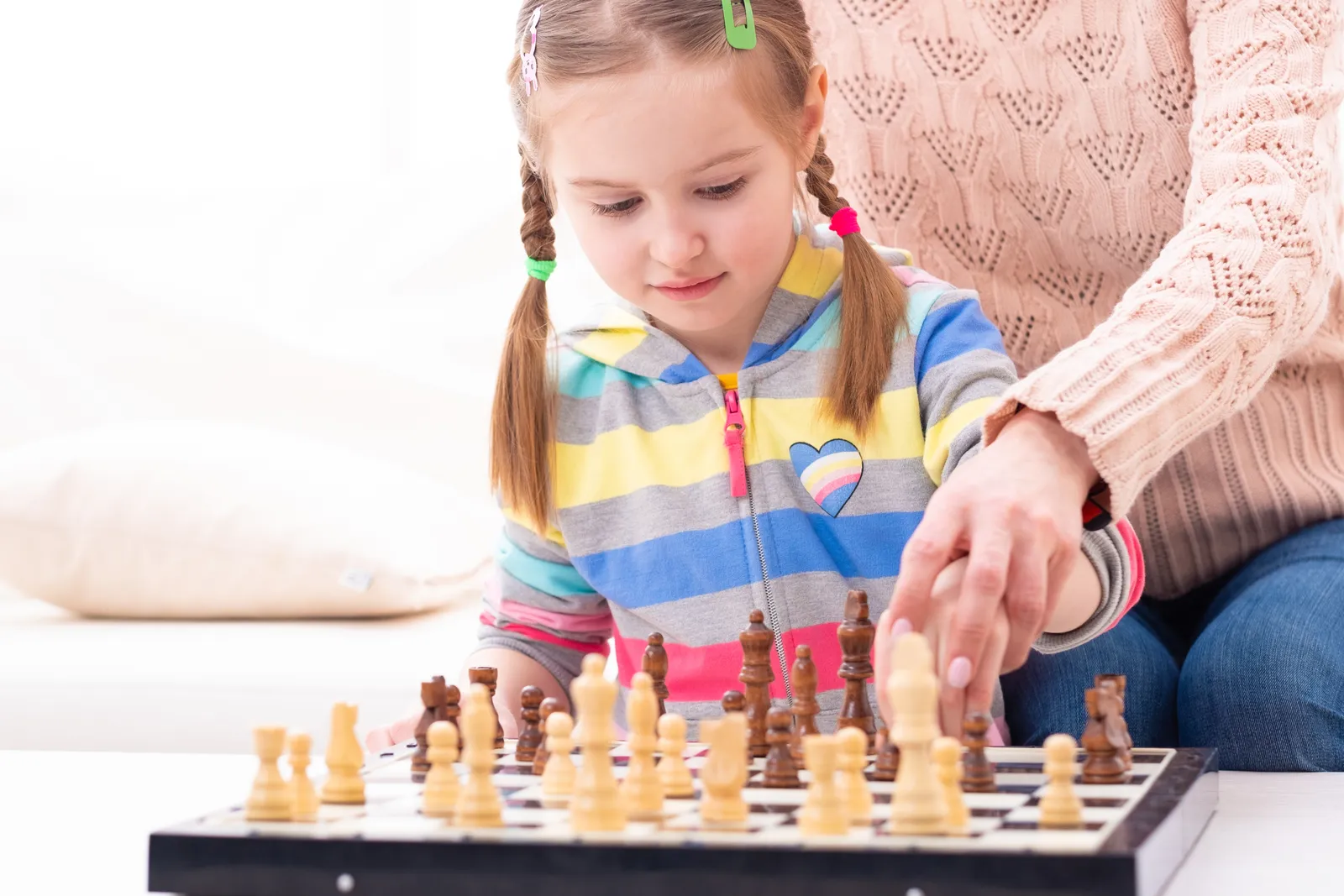 Chess instructor coaching two elementary-age students across a chessboard during a lesson