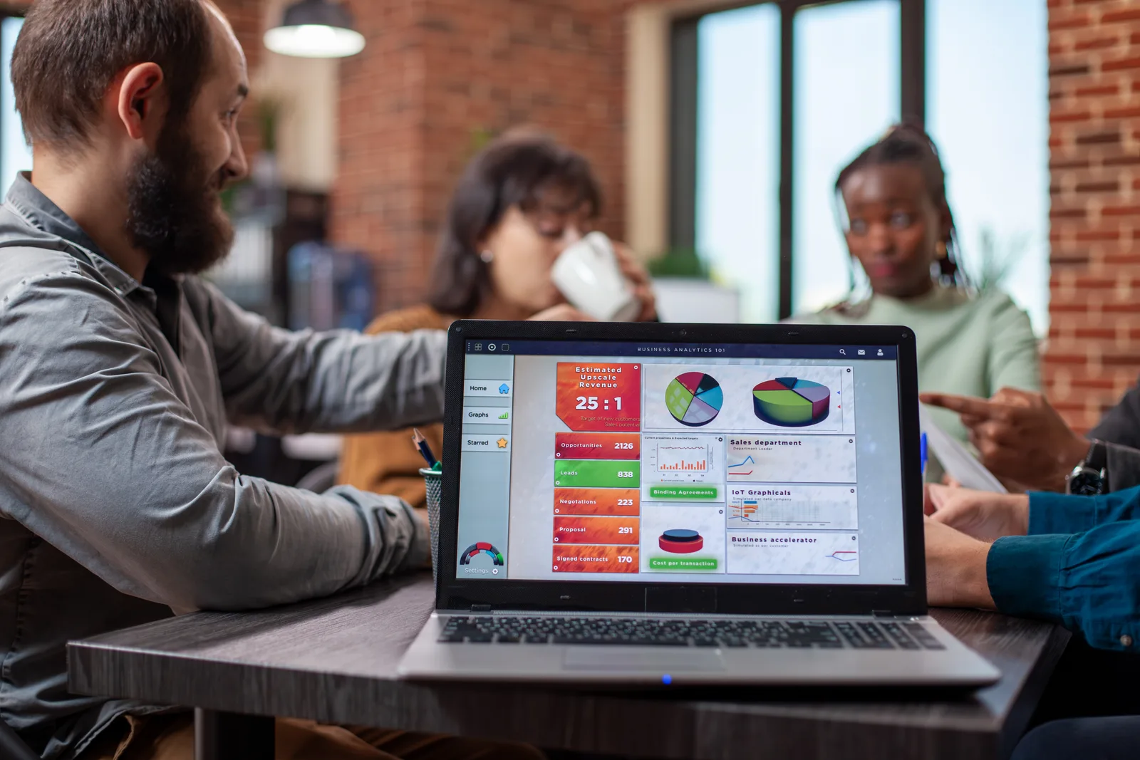 Childcare software product team reviewing center enrollment and billing dashboards together on a laptop in their office