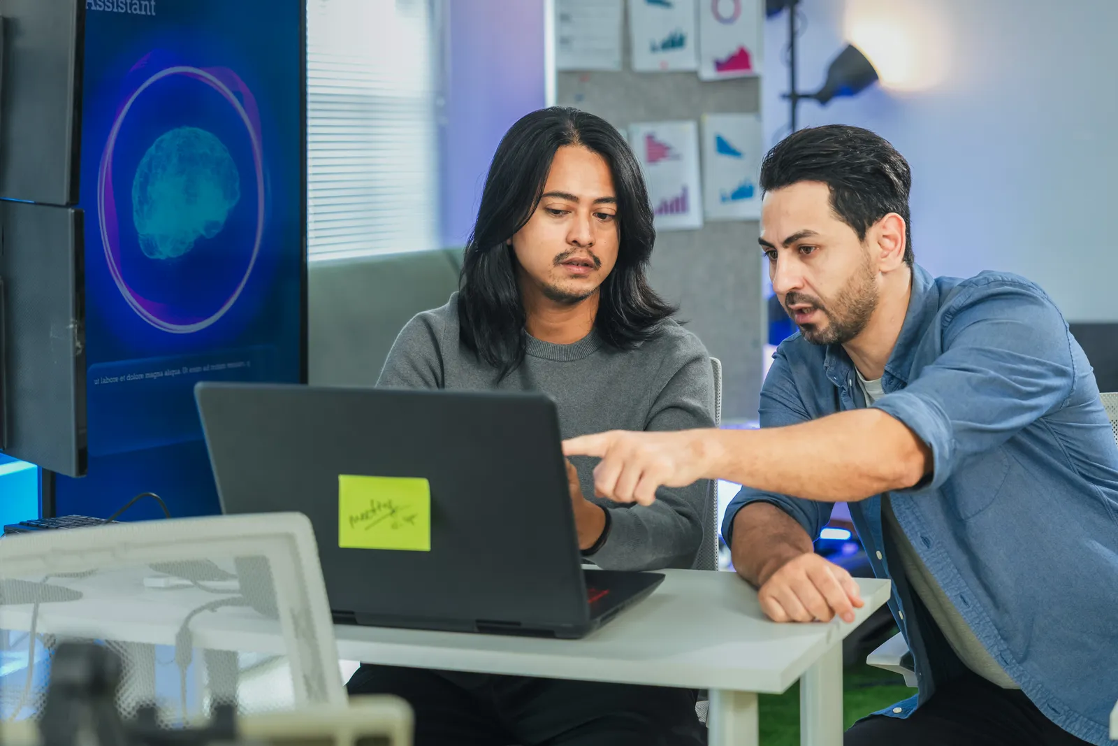 Chrome extension developer team reviewing install and rating data together at a laptop in their office
