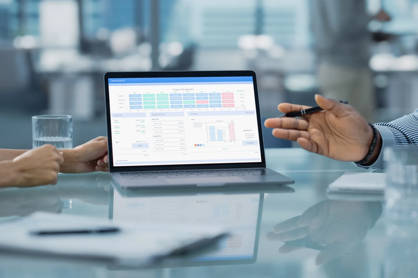 Claims operations director and IT manager reviewing FNOL intake and adjudication data together on a claims management software dashboard