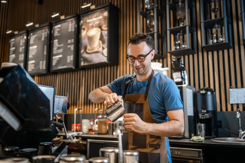 Barista making coffee at a cafe counter