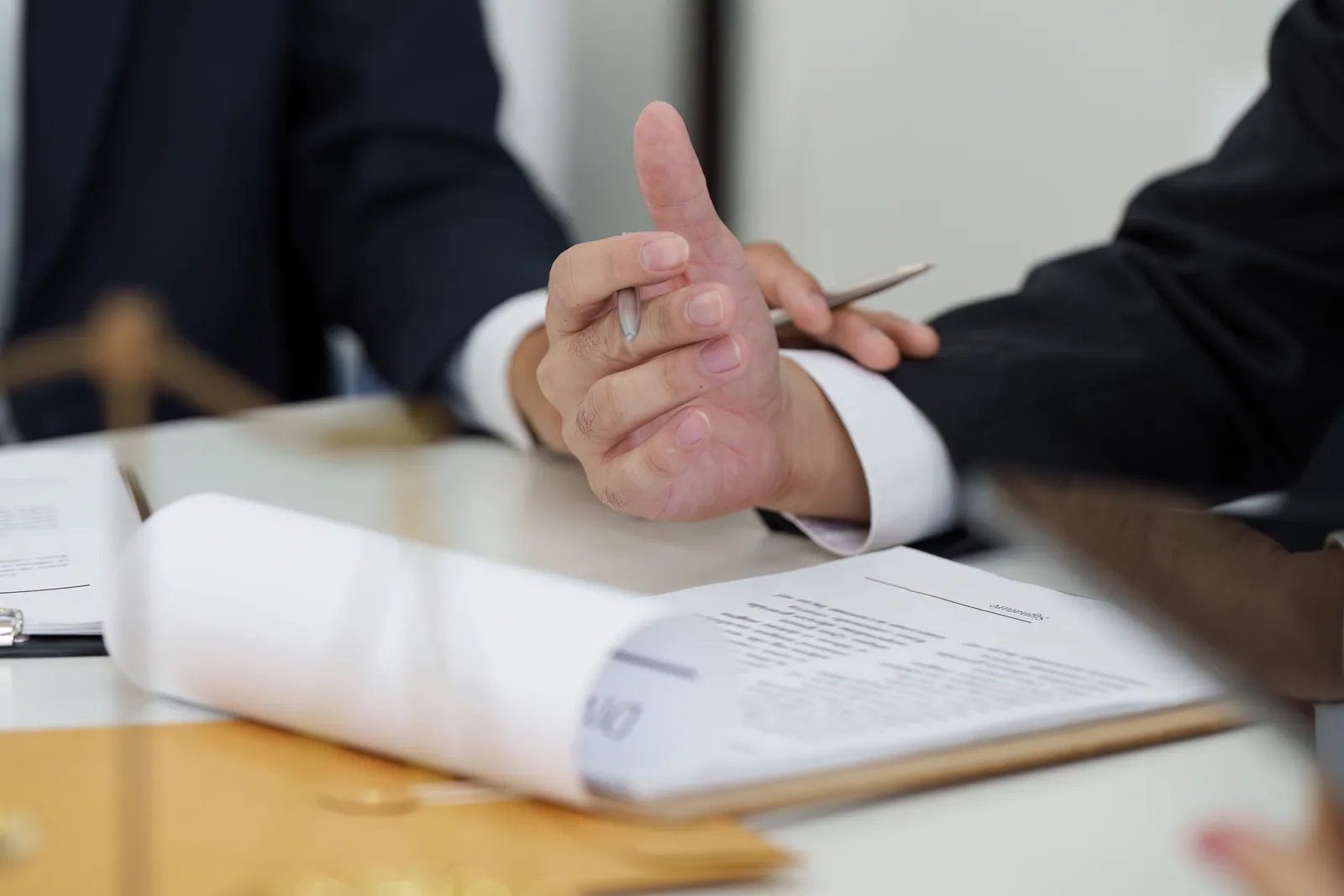 Construction accident attorney reviewing OSHA site-safety records and job-site photos with an injured worker at a law office conference table