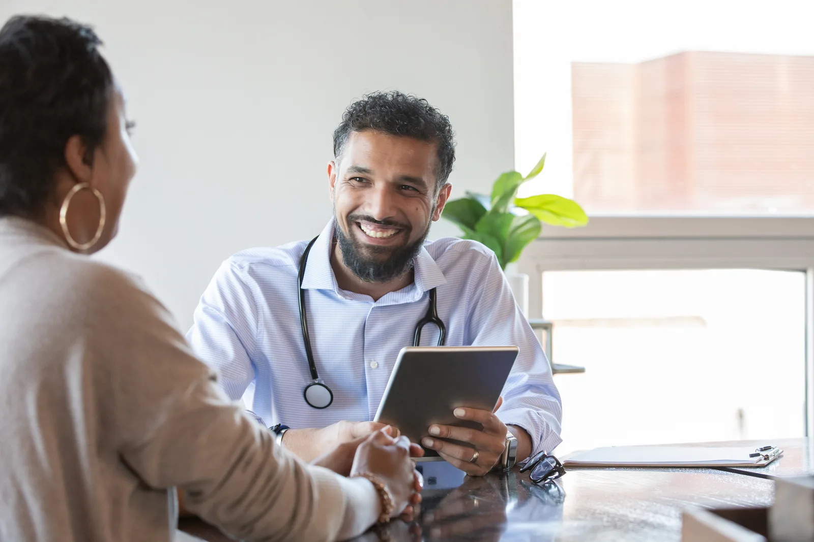 Plastic surgeon talking a prospective patient through procedure options in a private consultation room