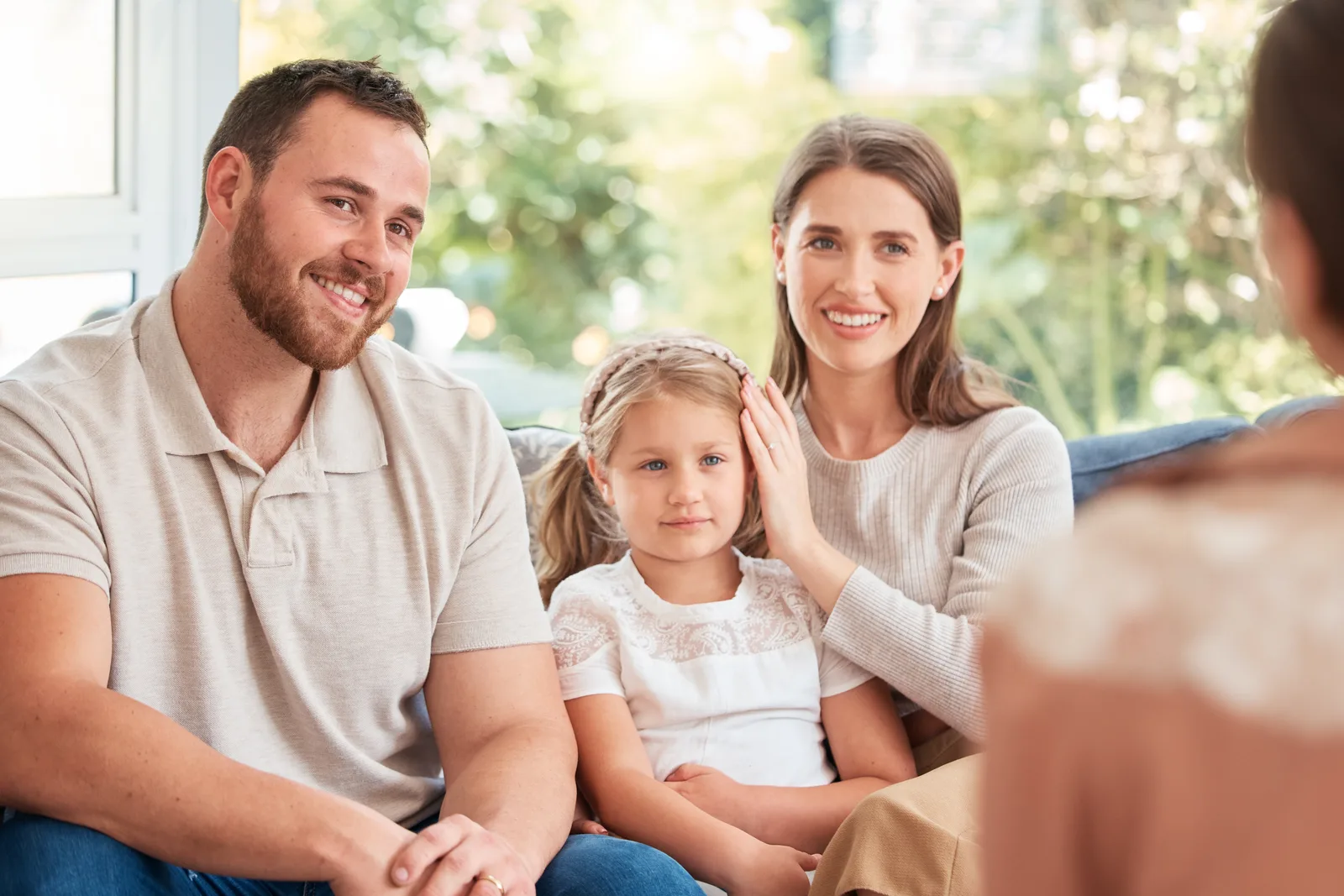 Couple sitting together on a couch talking with their therapist during a counseling session