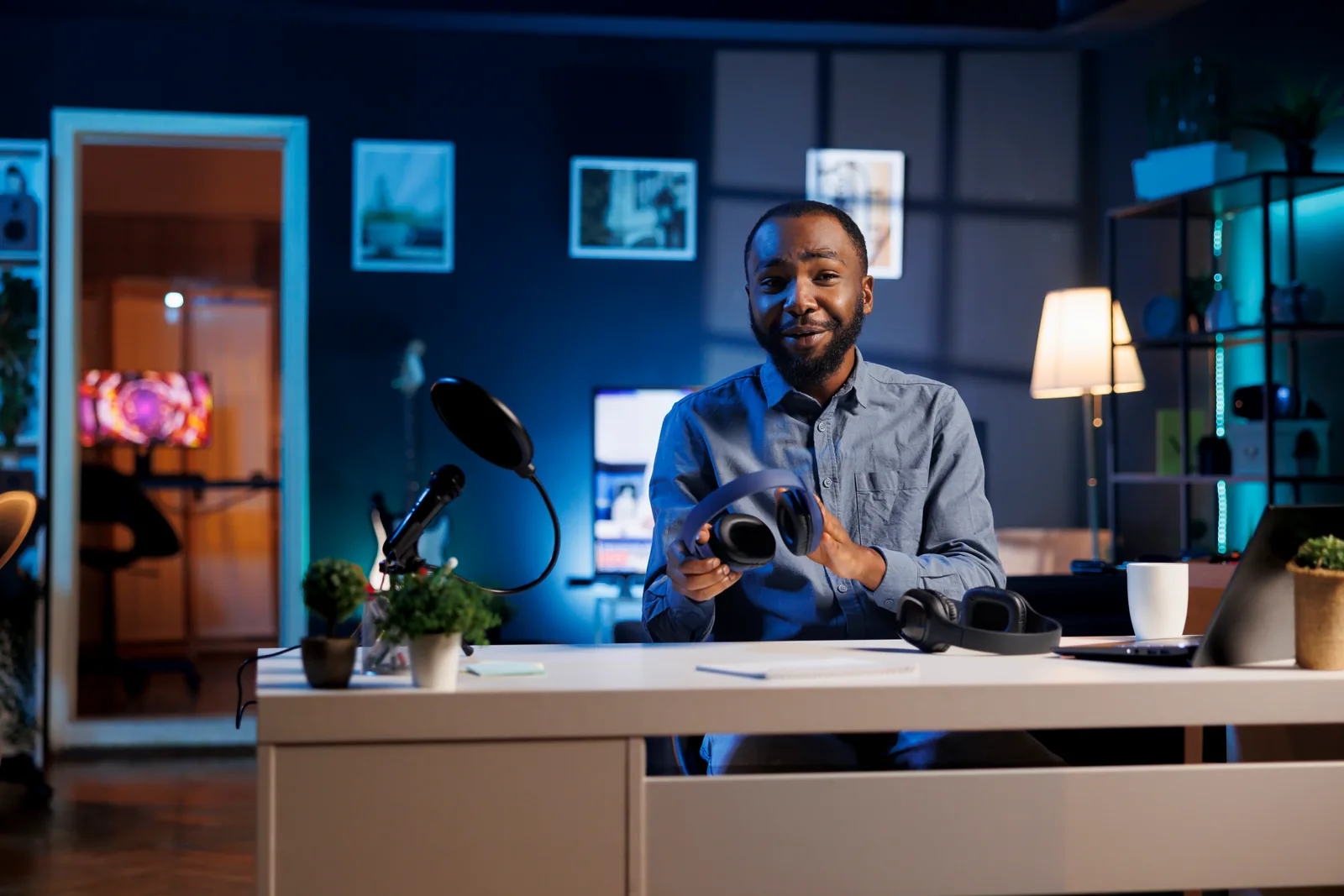 Online course creator recording a video lesson at a desk with a laptop, camera, and ring light