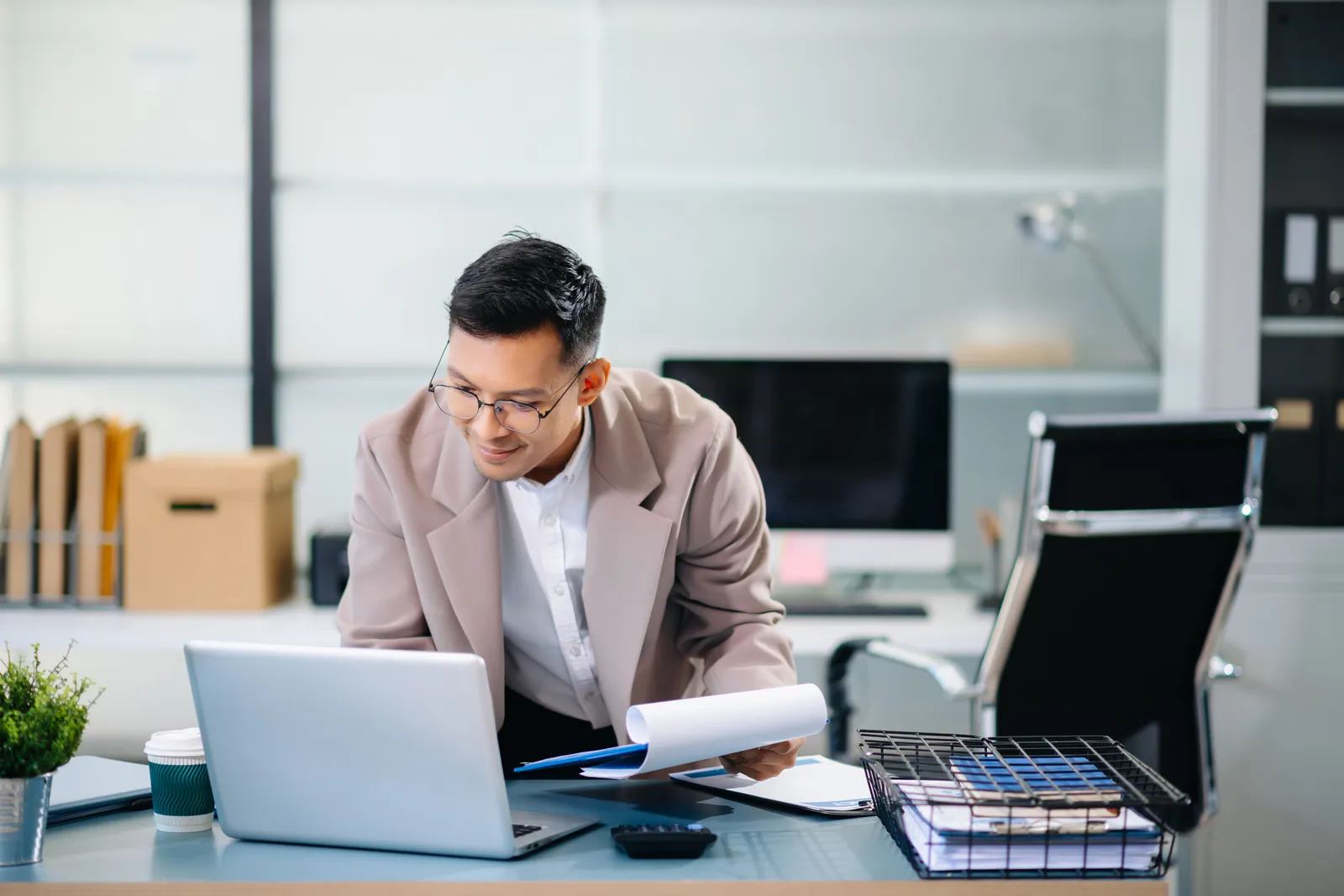 Sales operations professional reviewing a multi-line product quote and pricing rules on a laptop screen in an office