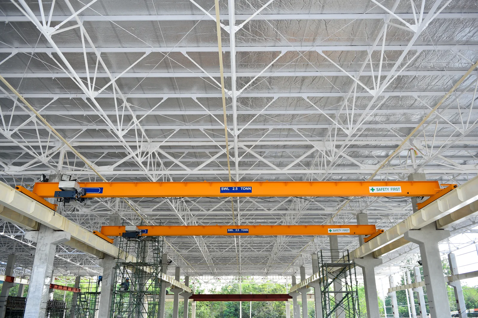 Mobile crane operator lifting a steel beam onto a commercial building under construction