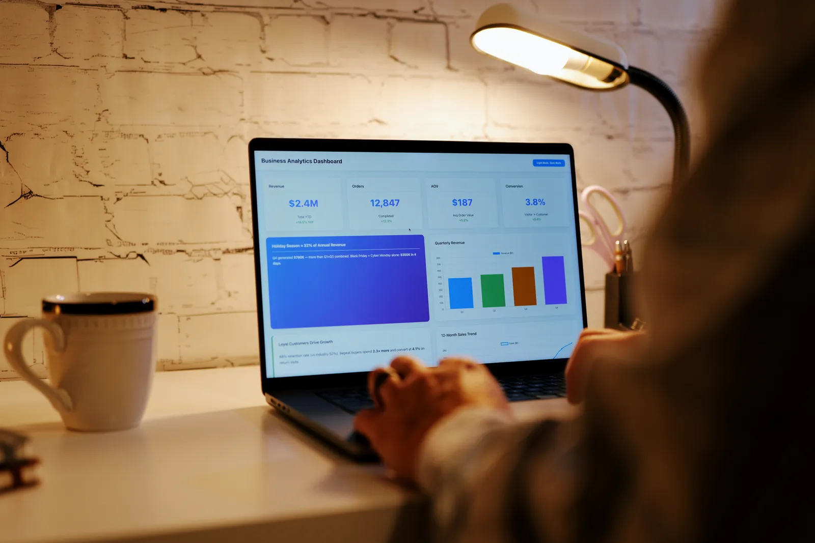 Creator reviewing membership subscriber and renewal numbers on a laptop at their desk