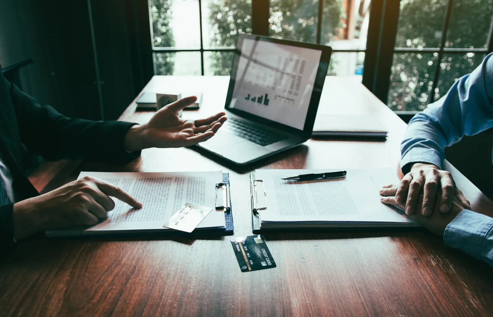 A credit union member services representative helping a new member open an account at a branch counter