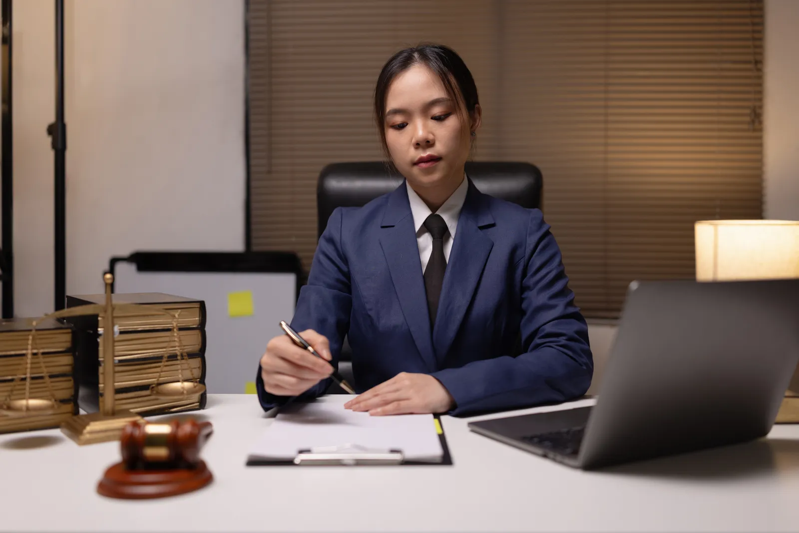Criminal appeals attorney reviewing a trial transcript and marking up an appellate brief at her desk