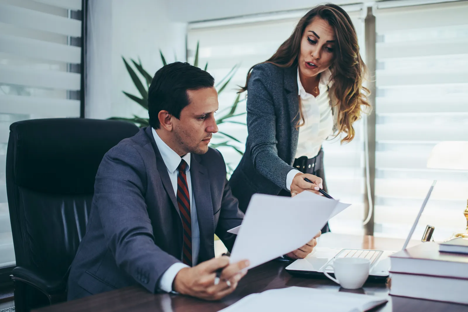 Crypto and blockchain attorney reviewing an agreement with a client at a law office desk