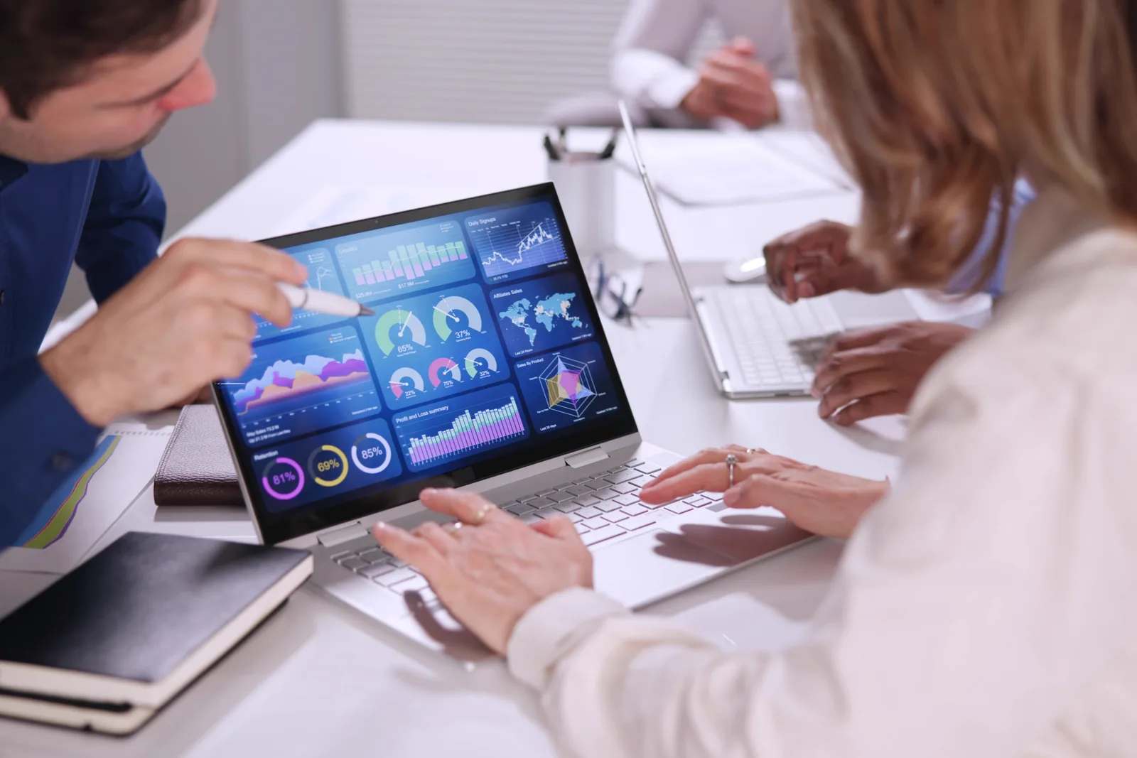 Marketing and data team reviewing a unified customer profile dashboard together on a laptop in their office