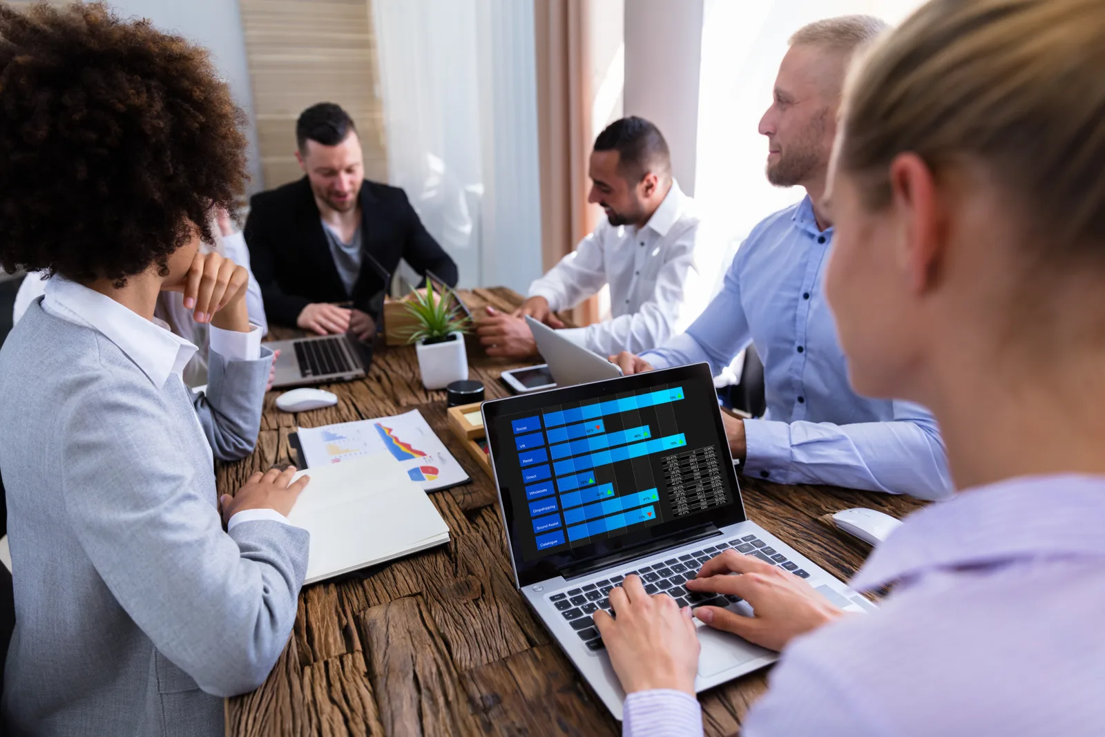 Customer experience team reviewing voice-of-customer survey and sentiment dashboards together at a laptop in their office