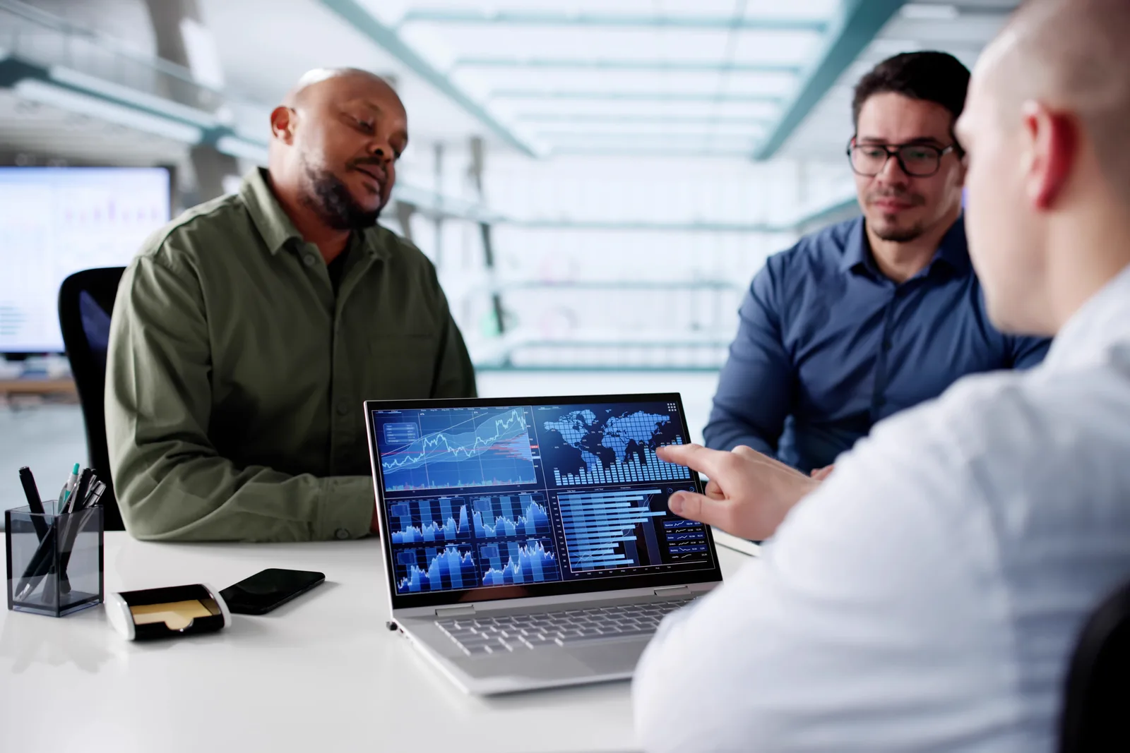 Cybersecurity SaaS team reviewing a security dashboard together on a laptop in a modern office