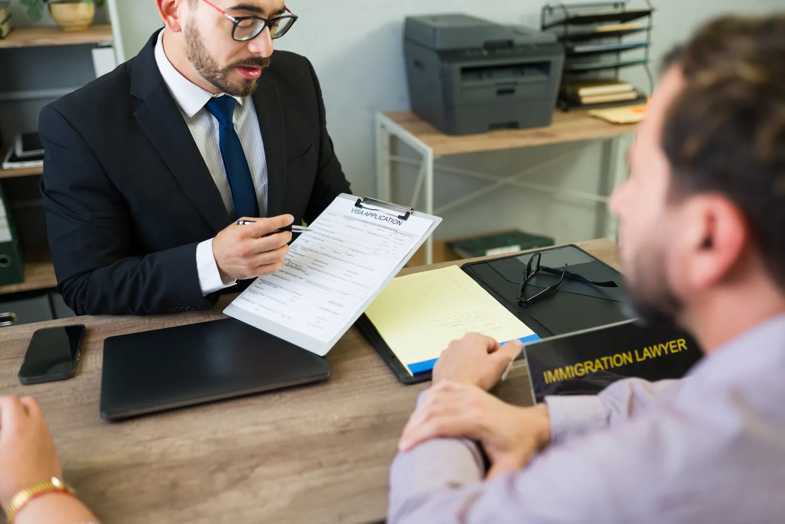 DACA immigration attorney reviewing a client's renewal application and work permit paperwork together at her desk