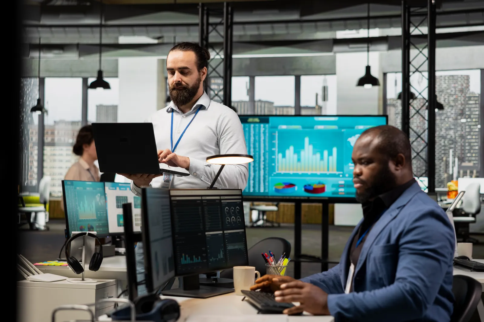 Data engineers reviewing a pipeline sync status dashboard together on a laptop in their office