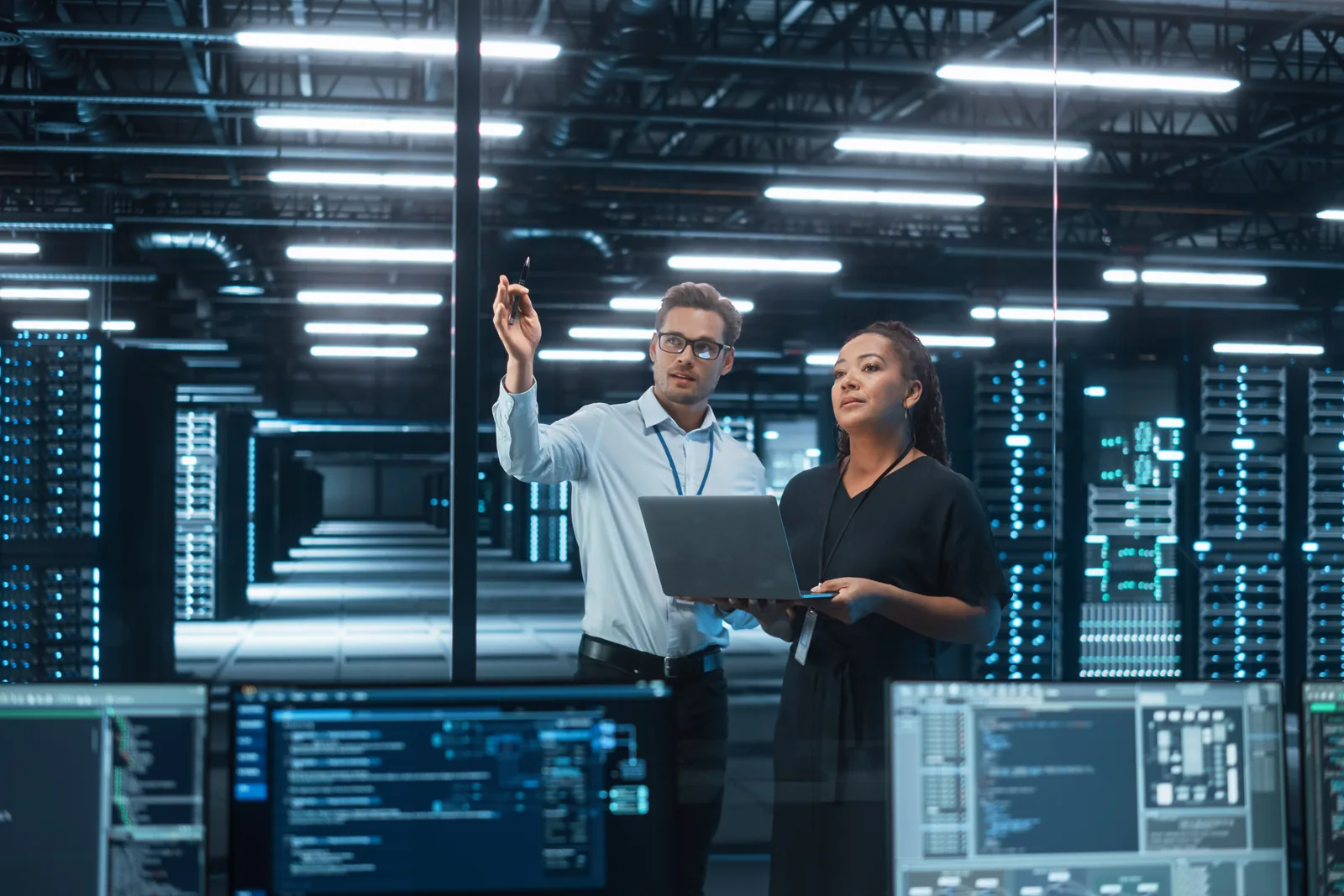 Data engineers reviewing a query performance chart together on a laptop in their office