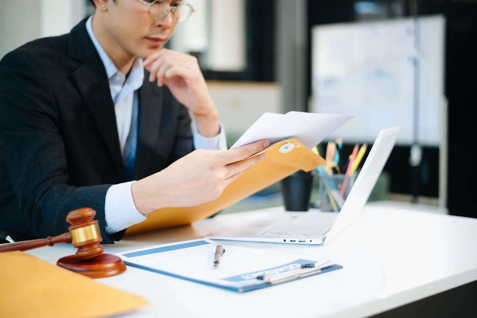 Debt collection defense attorney reviewing a client's lawsuit summons and collection letters at his desk