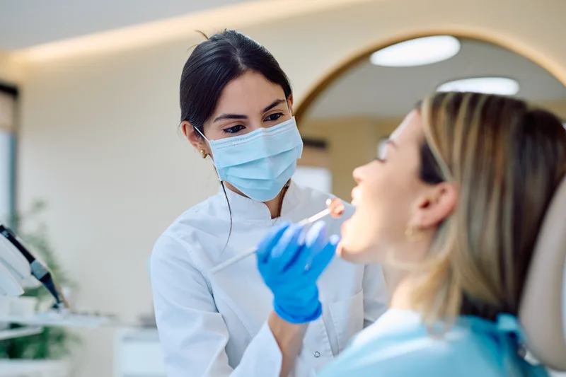 Dentist examining a patient during a routine checkup in a modern, bright dental clinic