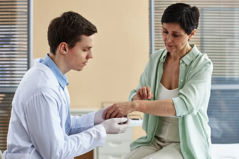 Dermatologist examining a patient's skin during a consultation in a clinic