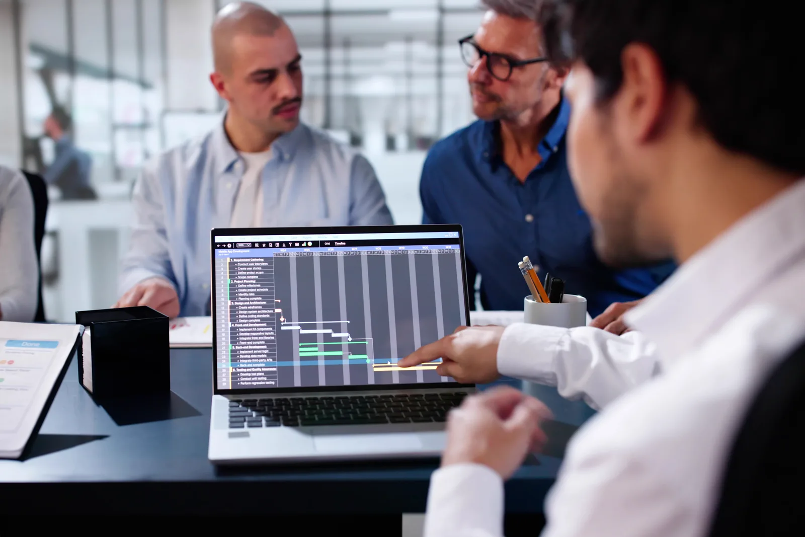 DevOps engineering team reviewing a CI/CD pipeline dashboard together at a laptop in their office
