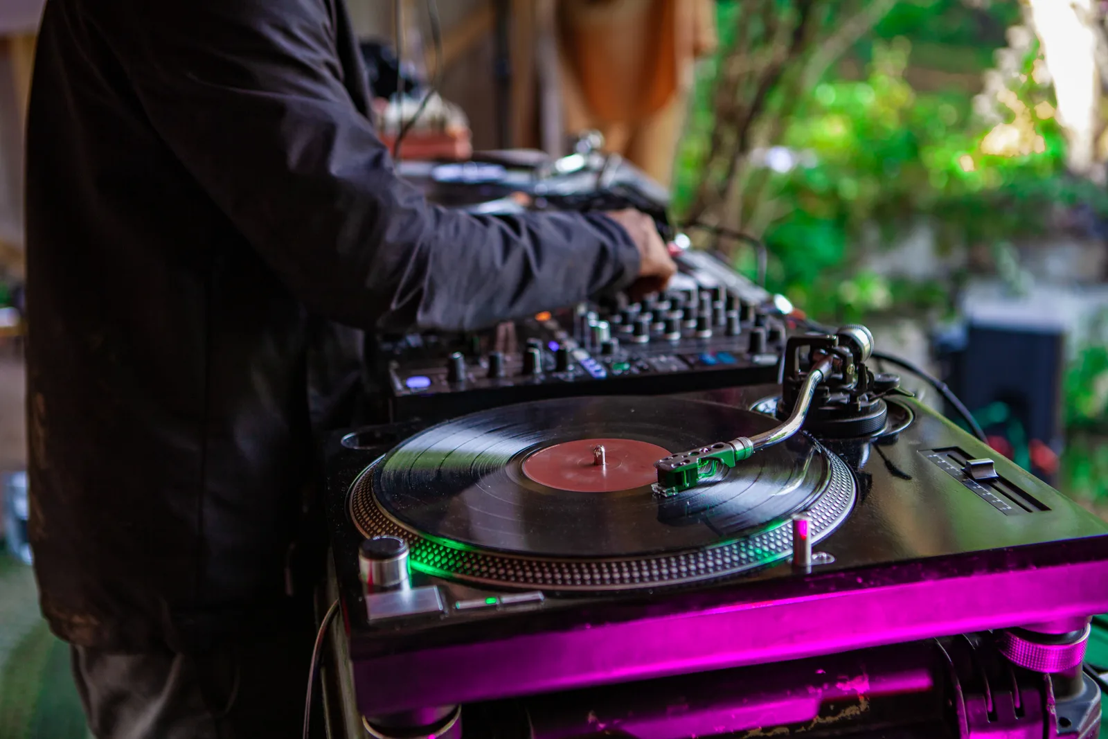 DJ mixing at a booth while guests fill the dance floor at a wedding reception