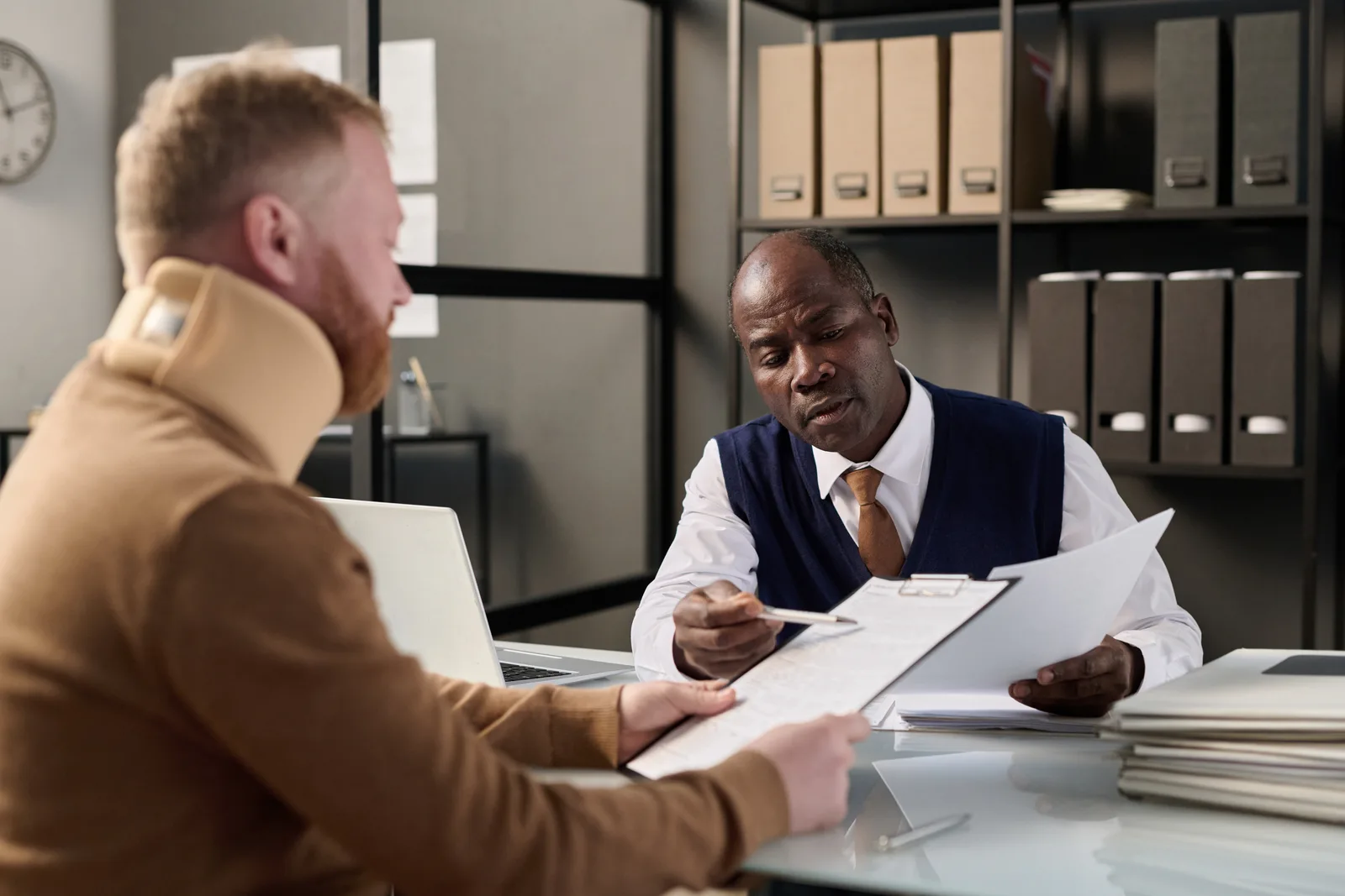 Personal injury lawyer reviewing a dog bite victim's medical records and injury photos with the client at a law office conference table