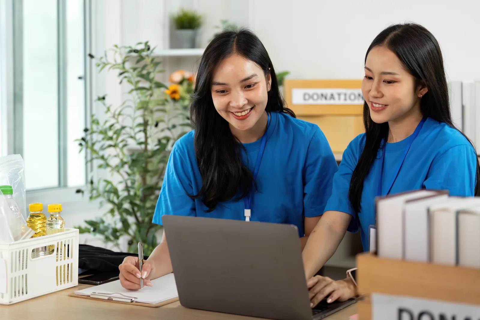 Donor management software product team reviewing nonprofit donor and giving dashboards together on a laptop in their office