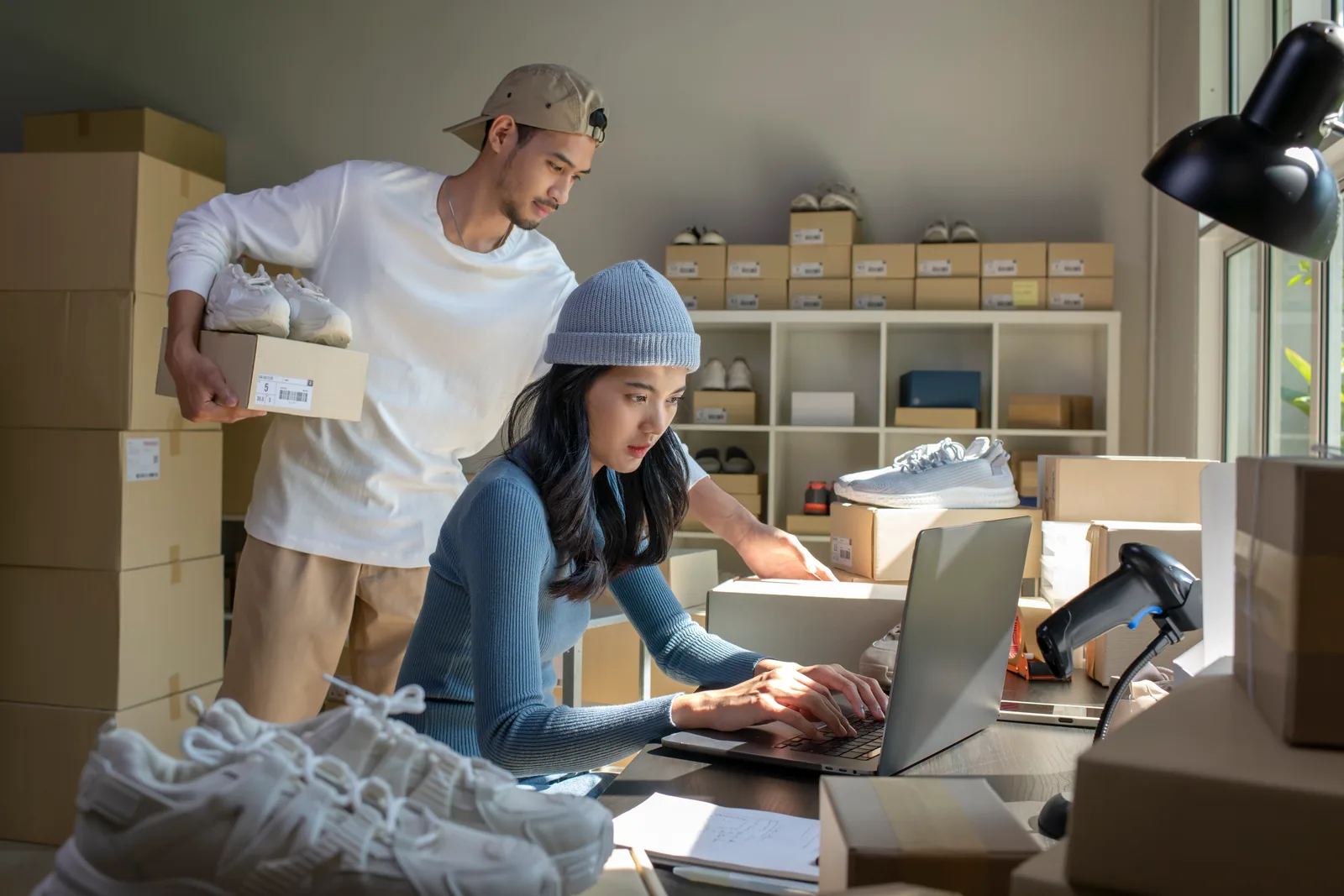 E-commerce store owners packing customer orders into shipping boxes